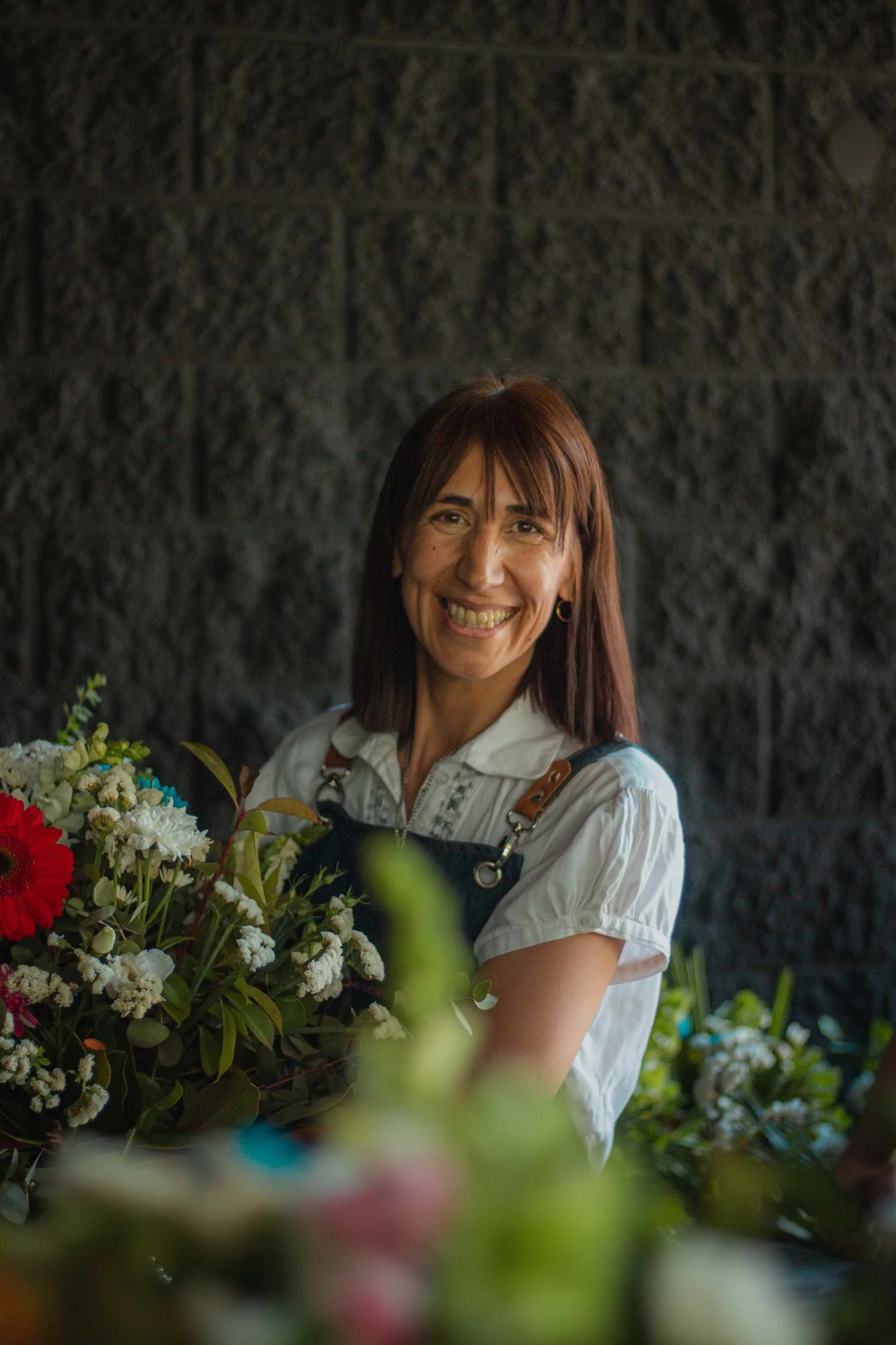 Sandra sonriendo entre flores