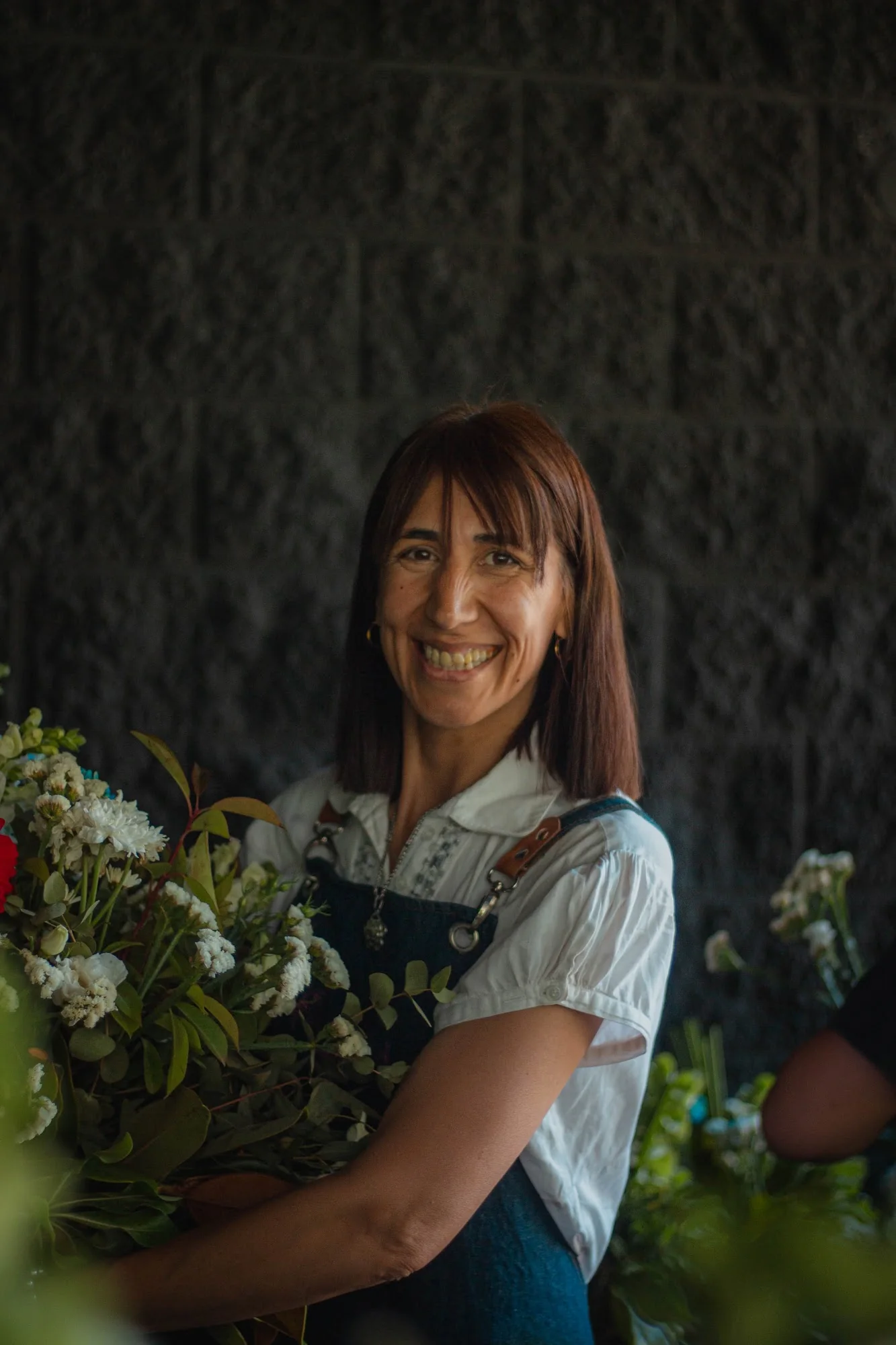 Sandra sonriendo con flores